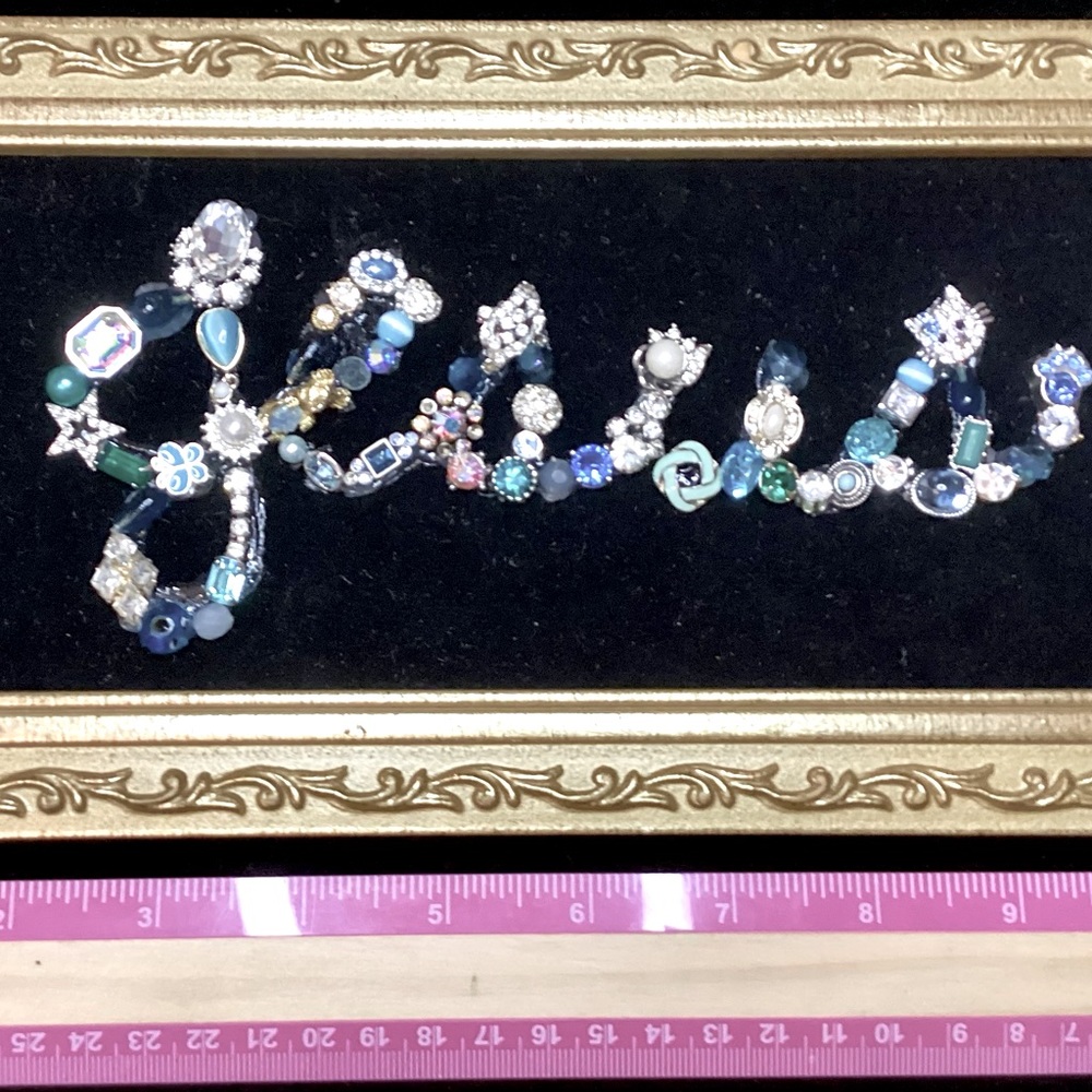 The name of Jesus done on Black velvet with blue,  silver and beaded jewelry